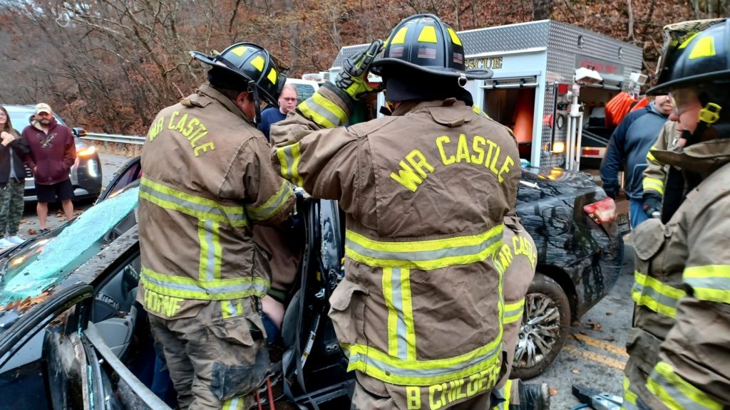 Firefighters work to free a pregnant woman trapped in her car following a crash Sunday morning.