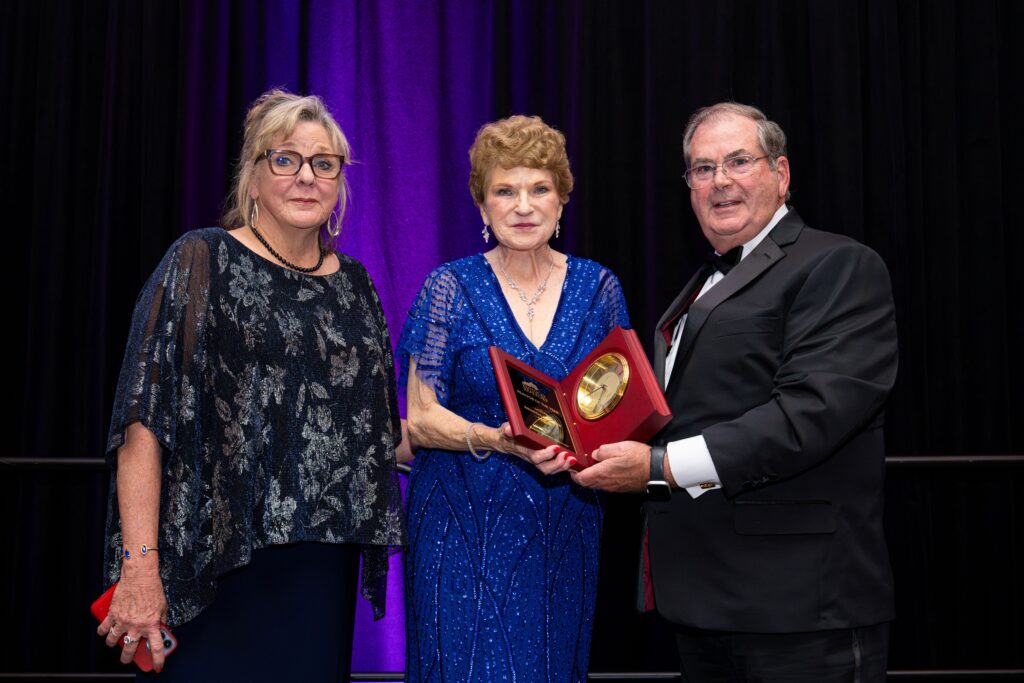 Brenda Gooslin receives her 2025 Realtor of the Year award from Kentucky Realtors President Barb Curtis and Kentucky Realtors Past President Mike Inman. 