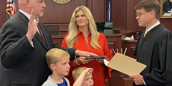 Christopher Todd Gilbert is administered the oath of office by U.S. District Judge Thomas Cullen, as hiw wife and sons look on.