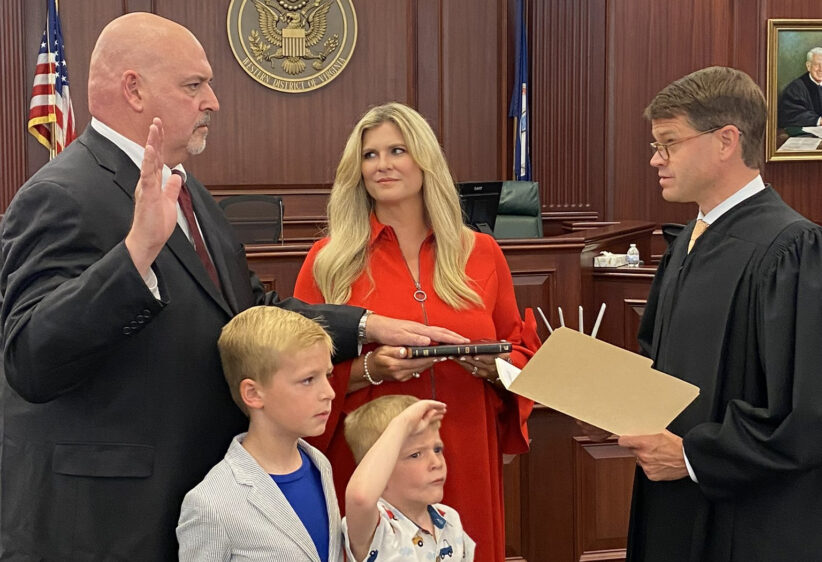 Christopher Todd Gilbert is administered the oath of office by U.S. District Judge Thomas Cullen, as hiw wife and sons look on.